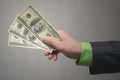 Businessman hand is stretching a dollars money isolated on gray background with copy space background. Financial help. Bribe and c Royalty Free Stock Photo