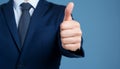 Businessman hand thumb up on blue punched paper Royalty Free Stock Photo