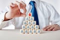 Businessman hand is about to flick the CEO icon at the top of the tiered wooden cubes Royalty Free Stock Photo