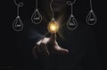 Businessman hand touching glowing lightbulb among lamp does not light for selective creative smart thinking ideas and innovation