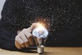 Businessman hand touching lightbulb with glowing virtual brain and connection line to creative smart thinking for inspiration and
