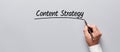 Businessman hand underlining the word content strategy on gray background. Planning business or media content strategy