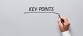 Businessman hand underlining the word key points on gray background. Highlighting the key points of an issue in business