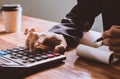 Businessman hand using calculator Calculating bonusOr other compensation to employees to increase productivity.Writing paper on Royalty Free Stock Photo