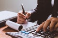 Businessman hand using calculator Calculating bonusOr other compensation to employees to increase productivity.Writing paper on Royalty Free Stock Photo