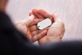 Businessman hand on wooden table holding dog tag Royalty Free Stock Photo