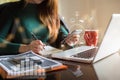 Businessman hand working at a computer and writing on a notepad with a pen in the office. Royalty Free Stock Photo