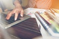 Businessman hand working laptop on wooden desk, Use the accompany article in finance. vintage effect.