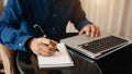 Businessman hand working with new modern computer and writing on the notepad strategy diagram as concept Royalty Free Stock Photo