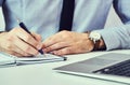 Businessman hand writing note on a notebook. Business man working at office desk. Close up of empty notebook on a Royalty Free Stock Photo