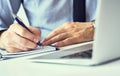 Businessman hand writing note on a notebook. Business man working at office desk. Close up of empty notebook on a Royalty Free Stock Photo