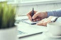 Businessman hand writing note on a notebook. Business man working at office desk. Close up of empty notebook on a Royalty Free Stock Photo