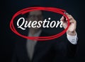 Businessman hand writing `Question` with red marker on transparent board.