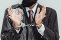 Businessman in handcuffs arrested isolated on gray background