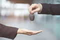 Businessman handing over gives the car key to the other woman on showroom Royalty Free Stock Photo