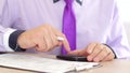 Businessman hands with calculator and pen writing and filing papers or tax form Royalty Free Stock Photo