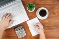 Businessman hands on laptop drinking coffee. calculator and notebook. Workplace in the office, coffee break Royalty Free Stock Photo