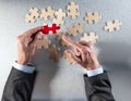 Businessman hands pointing a different jigsaw piece from puzzle group Royalty Free Stock Photo