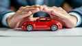 Businessman hands protecting red toy car on desk. Concept of auto protection and insurance. Royalty Free Stock Photo