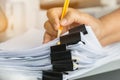 Businessman hands searching and checking write unfinished documents stacks of paper files on office desk for report papers with Royalty Free Stock Photo