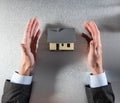 Businessman hands showing a house to buy, above view