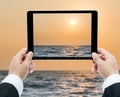 Businessman hands tablet taking pictures beach and sea