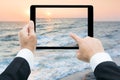Businessman hands tablet taking pictures beach and sea