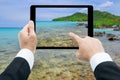 Businessman hands tablet taking pictures beach and sea