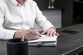 Businessman hands taking notes or writing agenda in planner at office workplace. Business planning and strategy concept