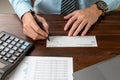 Businessman hands writing and signing check. business, finances and money concept