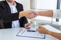 Businessman handshake with money of dollar banknotes in hands from money of their partner to give success the deal contract in a Royalty Free Stock Photo