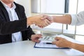 Businessman handshake with money of dollar banknotes in hands from money of their partner to give success the deal contract in a Royalty Free Stock Photo