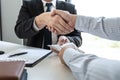 Businessman handshake with money of dollar banknotes in hands from money of their partner to give success the deal contract in a Royalty Free Stock Photo