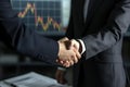 businessman handshake on trade chart concept