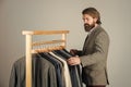 Businessman handsome guy in clothes shop choosing garments, demanding customer concept