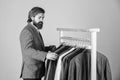 Businessman handsome guy in clothes shop choosing garments, demanding customer concept