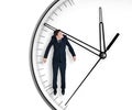 Businessman hangs on an arrow of clock