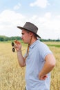 Businessman harvester. Portrait of farmer standing in gold wheat field with blue sky in background. Young man wearing Royalty Free Stock Photo