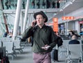 Businessman in a hat standing at the airport,talking by cellphone . Royalty Free Stock Photo