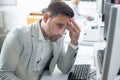 Businessman having head pain while working on computer in office. Royalty Free Stock Photo