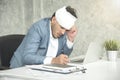 Businessman headache and bandage from work injury at workplace. Royalty Free Stock Photo