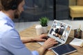 Businessman in headphones speak talk on video call with colleagues on online briefing during self isolation