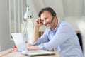 Businessman with headset teleworking on laptop Royalty Free Stock Photo