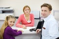 Businessman and her daughter sit in office of realtor.