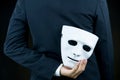 Businessman hide the white mask in the hand behind his back on b Royalty Free Stock Photo