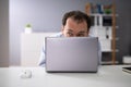 Businessman Hiding Behind Laptop