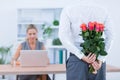 Businessman hiding flowers behind back for colleague Royalty Free Stock Photo