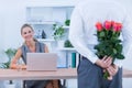 Businessman hiding flowers behind back for colleague Royalty Free Stock Photo