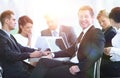 Businessman and his business team with financial documents sitting at a Desk in the lobby of the Bank. Royalty Free Stock Photo