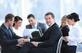 Businessman and his business team with financial documents sitting at a Desk in the lobby of the Bank. Royalty Free Stock Photo